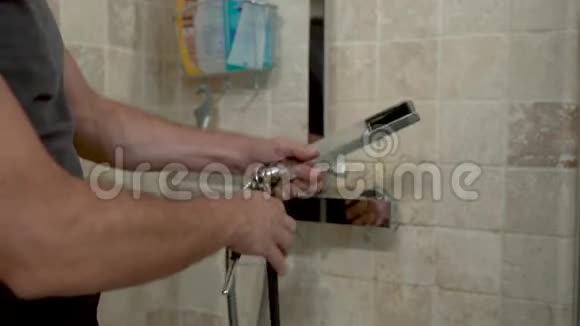 男水管工把淋浴头换成浴室里的新喷头4K视频视频的预览图
