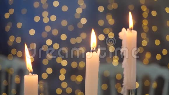 明亮美丽的背景以灯光的形式为三支蜡烛舒适的气氛和过冬的准备视频的预览图