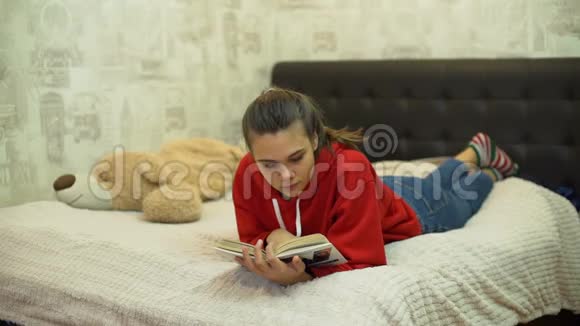少女床上阅读书籍视频的预览图