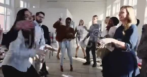 现代多民族办公室的成功庆祝晚会快乐的商人们聚集在一起在时髦的工作场所跳舞视频的预览图