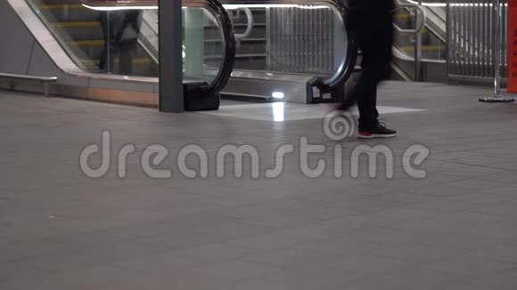 在火车站步行的乘客的腿背景中的自动扶梯左下角的文本空间视频的预览图