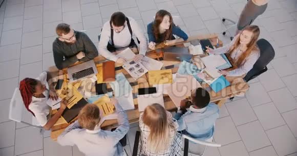 俯视图一群快乐的商人一起工作在潮流光现代办公室年轻的女领导讲话视频的预览图