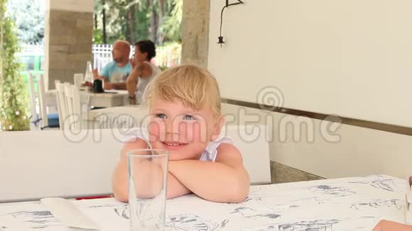 小女孩坐在咖啡馆里四处寻找食物视频的预览图