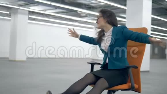 女工人跳舞坐在办公椅上玩得很开心视频的预览图