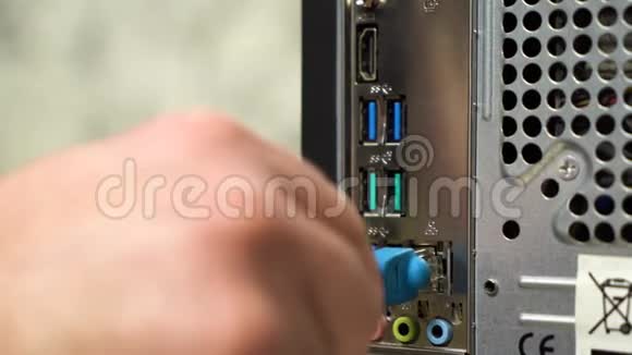 男性手将蓝色以太网电缆连接到计算机的背面关闭录像视频的预览图