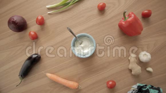 女人的手脱下来然后把希腊酸奶放在木桌上的蓝色碗里视频的预览图