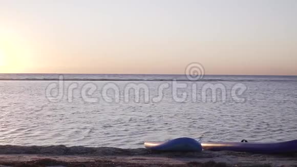 穿比基尼的年轻女子在海滩上散步日落时摆姿势视频的预览图