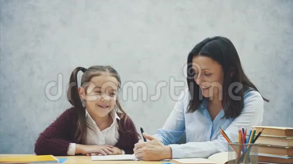 幼师帮孩子写课或母女学写妈妈教小女孩视频的预览图
