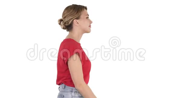 穿牛仔裤和白色背景的t恤走路的女人视频的预览图