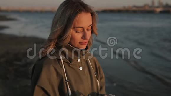 站在河边用耳机听音乐的女人视频的预览图