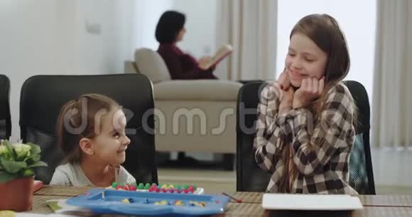 两个小妹妹在桌上玩游戏时很有魅力笑容可掬她们玩得很开心视频的预览图