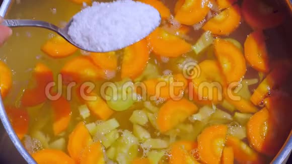 一个女人准备了一个素食汤里面有胡萝卜和辣椒并在里面加了盐视频的预览图