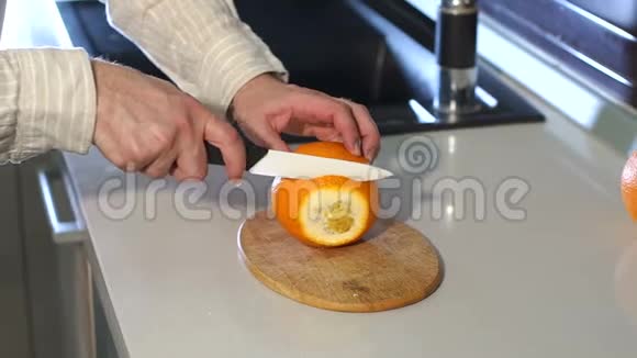 男手在厨房里切鲜橙色慢动作特写镜头视频的预览图