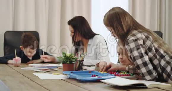一个有三个孩子的大家庭和一位美丽成熟的母亲在厨房的大桌子上共度时光视频的预览图