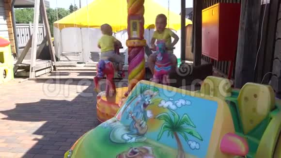 可爱的孩子坐在旋转木马上玩得很开心万向节运动视频的预览图