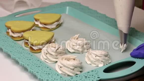 女人用糕点包做棉花糖在托盘旁边有棉花糖三明治视频的预览图