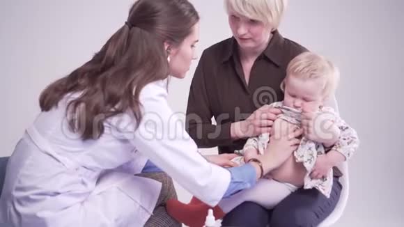 妈妈带着一岁的孩子和医生在一起医生用听诊器检查婴儿视频的预览图