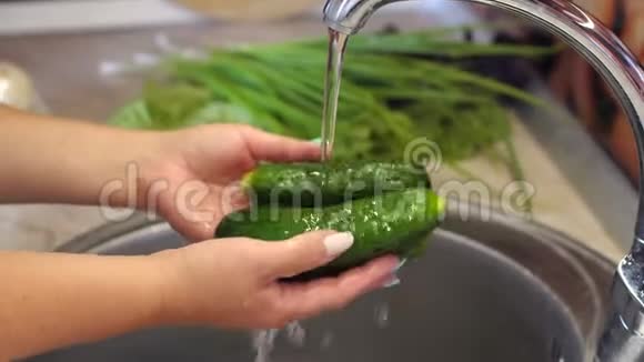 女家庭主妇在厨房水槽里洗新鲜黄瓜的特写镜头4K视频的预览图