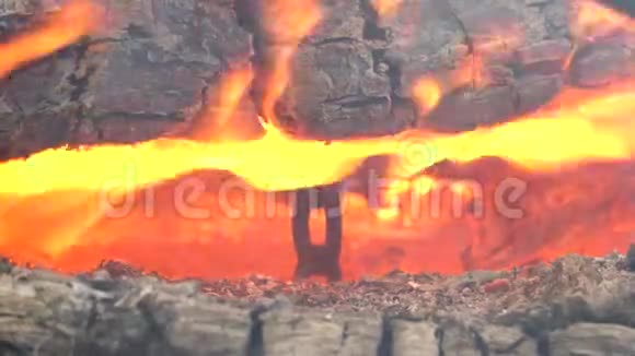 在炽热的火焰中一根金属链挂在原木之间视频的预览图