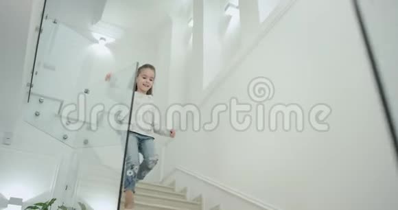 一个六岁的小女孩在一个现代化的房子设计楼梯她下来到一楼视频的预览图