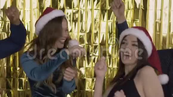在一个聚会上快乐快乐的人们戴着圣诞老人的帽子在一个聚会上跳舞很有趣一群笑的混在一起的人视频的预览图