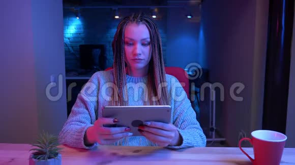 一位年轻有魅力的女性博客写手在平板电脑上玩电子游戏同时平板电脑上输了又输了视频的预览图