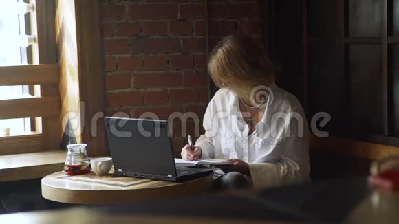 女商人在咖啡馆的日记里做笔记视频的预览图