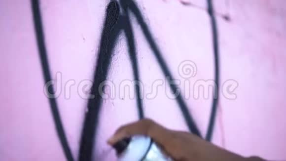黑人在墙上用喷漆画和平标志特写涂鸦视频的预览图