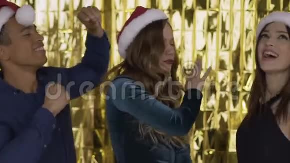 在一个聚会上快乐快乐的人们戴着圣诞老人的帽子在一个聚会上跳舞很有趣一群笑的混在一起的人视频的预览图