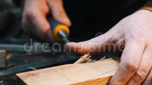 木工行业一名木工用凿子和他的手把木器上的凹处凿出来视频的预览图
