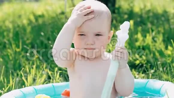 小可爱的小男孩在充气池玩喷水夏日视频的预览图