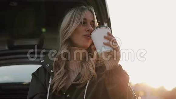 女人喜欢秋天喝热茶在车旁吃饼干视频的预览图
