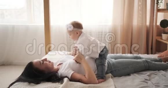 妈妈在床上和小女儿一起玩视频的预览图