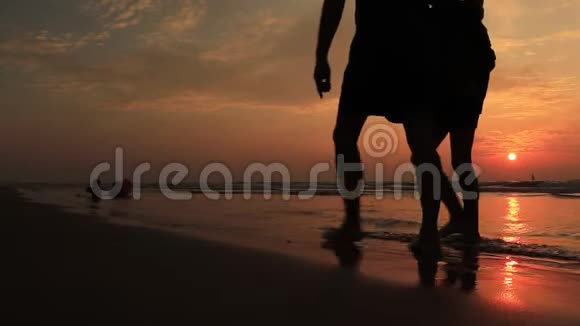 日落时分父子俩在海滩上散步友好家庭慢动作概念视频的预览图