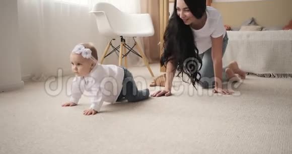 妈妈和小女孩在家里地毯上爬行视频的预览图