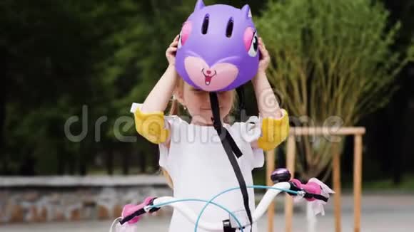 小女孩穿上保护自行车头盔骑自行车视频的预览图