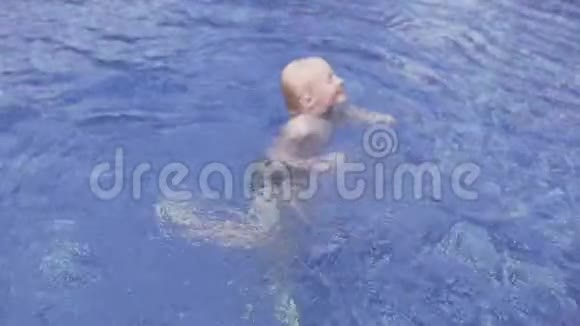 快乐的宝宝在夏天的游泳池里蹒跚学步视频的预览图