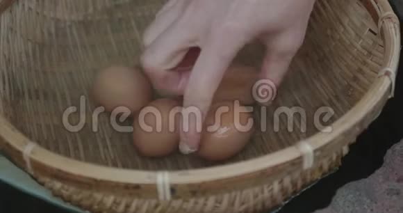 一位女士从一篮子鸡蛋中挑选出一个65度的安森鸡蛋在日本Ryokan以外的温泉水中出售视频的预览图