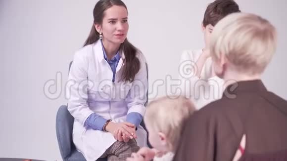 金发的母亲和7岁的儿子和小女儿在医生办公室视频的预览图