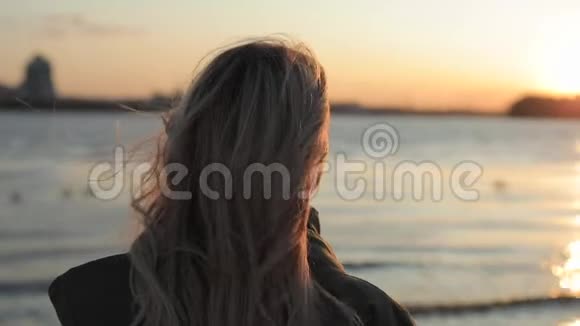 幸福的女人享受日落转过脸看着我站在河边视频的预览图