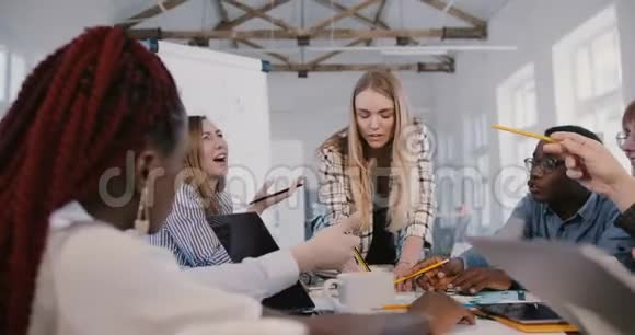 成功的严肃的年轻女商人在办公室头脑风暴团队会议上与多民族员工合作视频的预览图