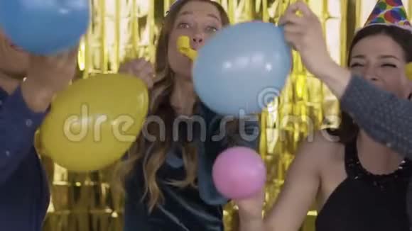 在一个聚会上快乐的人戴着纸帽打气球那些家伙在吹笛子跳舞A视频的预览图