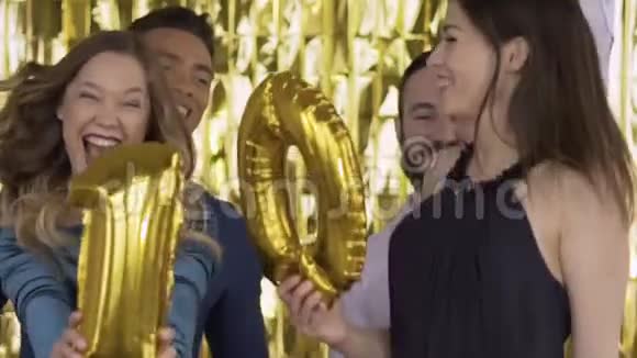 箔的数字10在一个聚会上快乐的人手里拿着气球一群笑的人视频的预览图