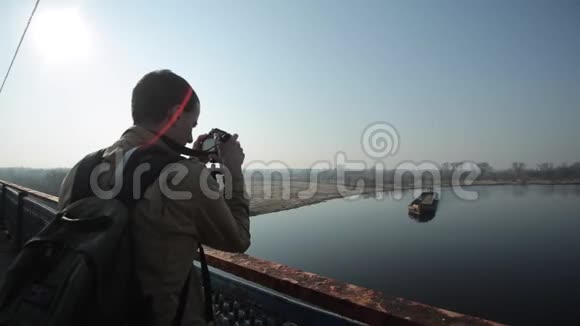 一个人拿起相机一艘漂浮在河上的长驳船视频的预览图