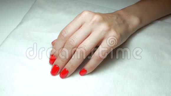 美丽的红色美甲在美容院女孩的手上慢动作视频的预览图