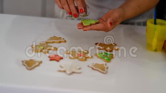 圣诞饼干的装饰过程靠近女人在节日的前夕带着悲伤的微笑装饰自制姜饼的男人视频的预览图