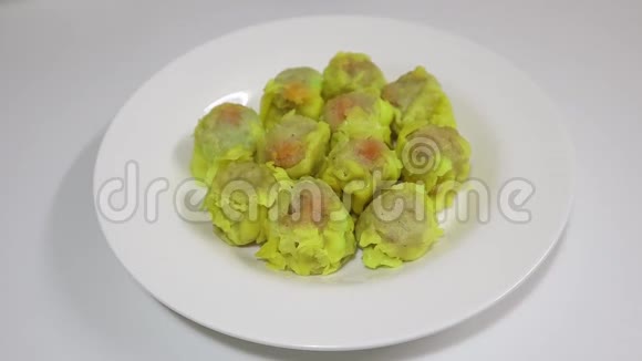 黄色的饺子放在白色的盘子里上面撒着大蒜视频的预览图