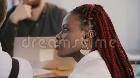 年轻积极的非裔美国职业商务女性点头听着同意在桌子后面讨论视频的预览图