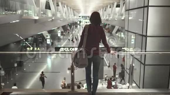 女乘客站着看现代机场大厅视频的预览图