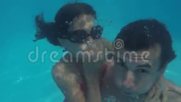 爸爸和女儿在水下的游泳池里男人和女孩十几岁的孩子在水下洗澡视频的预览图
